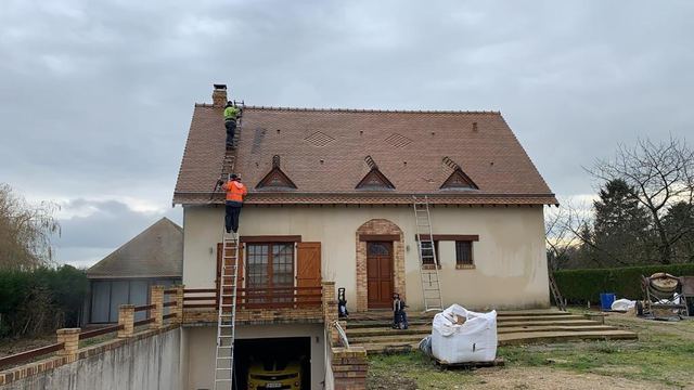 Nettoyage d'une toiture en petites tuiles plates sur une maison à lucarnes